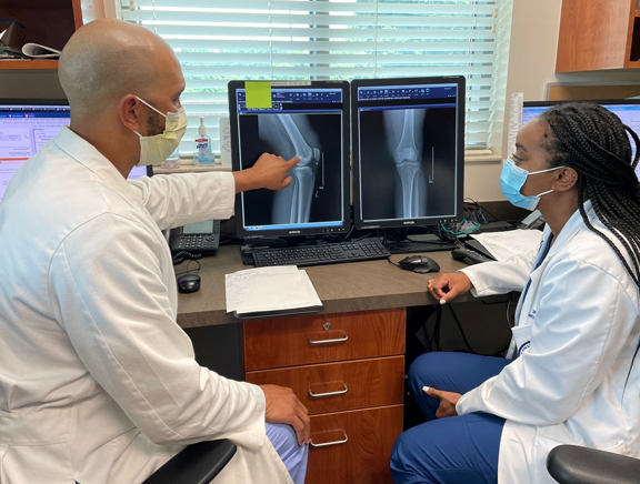 Orthopedic Specialist Doctor examining X-ray of a Patient's Knee Joint.